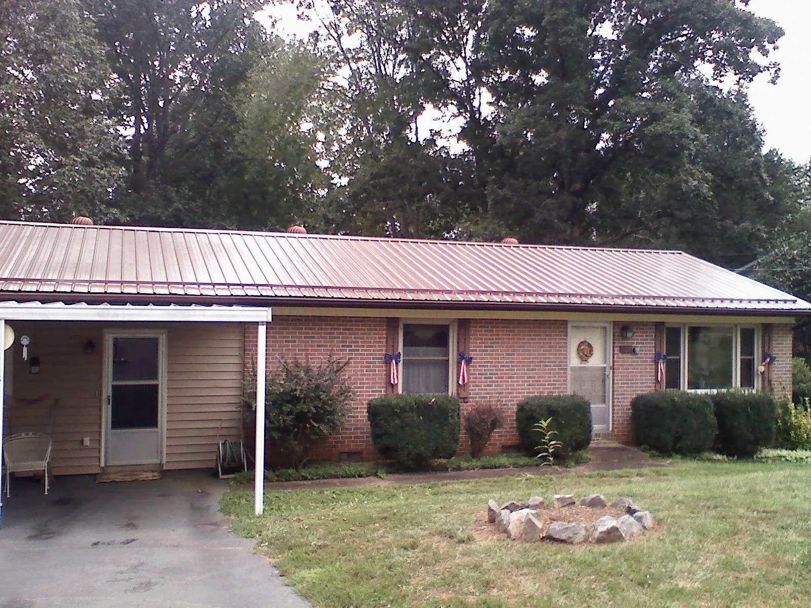 Bronze metal roof and carport on a brick ranch home — Roof Repair work by our crew in West Union